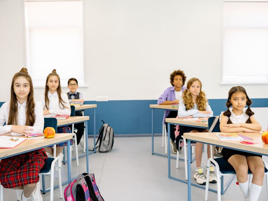 Sınıfta defterleri üzerinde çalışan ilköğretim öğrencileri